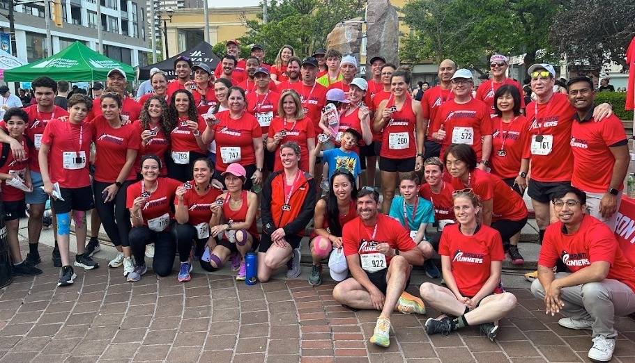 The Bronte Runners club posing together in the morning sun after the Mercedes-Benz Oakville Bronte Harbour Classic 5K at Bronte Heritage Waterfront Park, Oakville